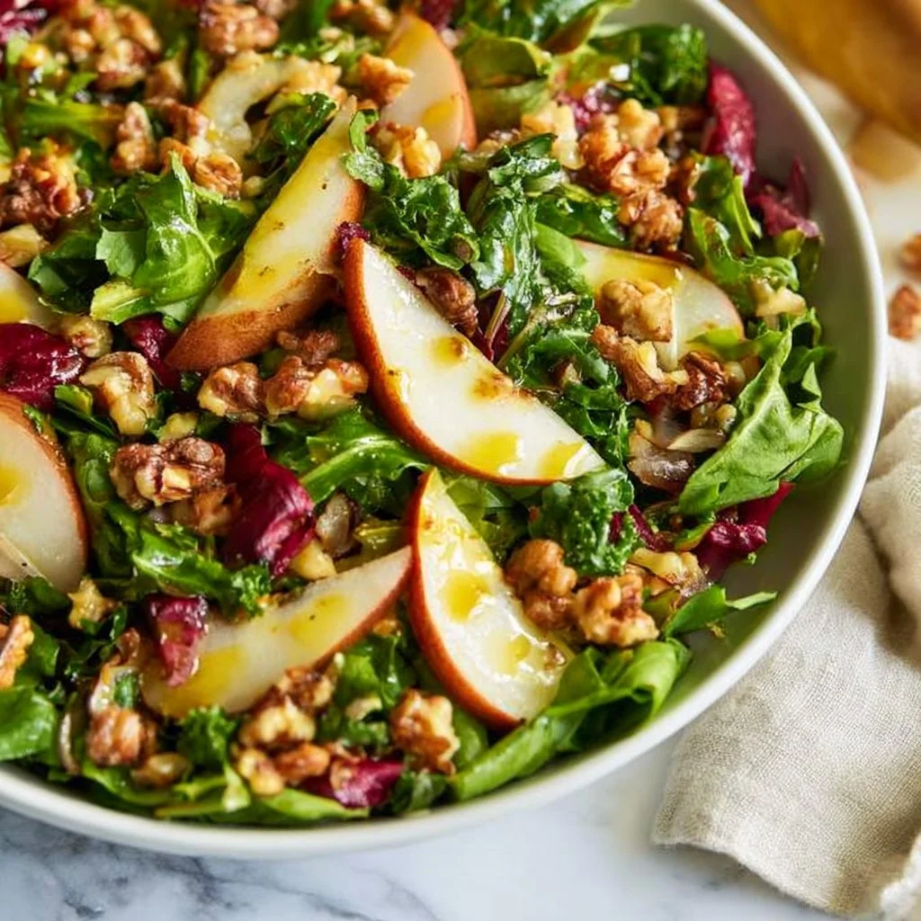 Kale salad with sliced pears and toasted walnuts in a bowl