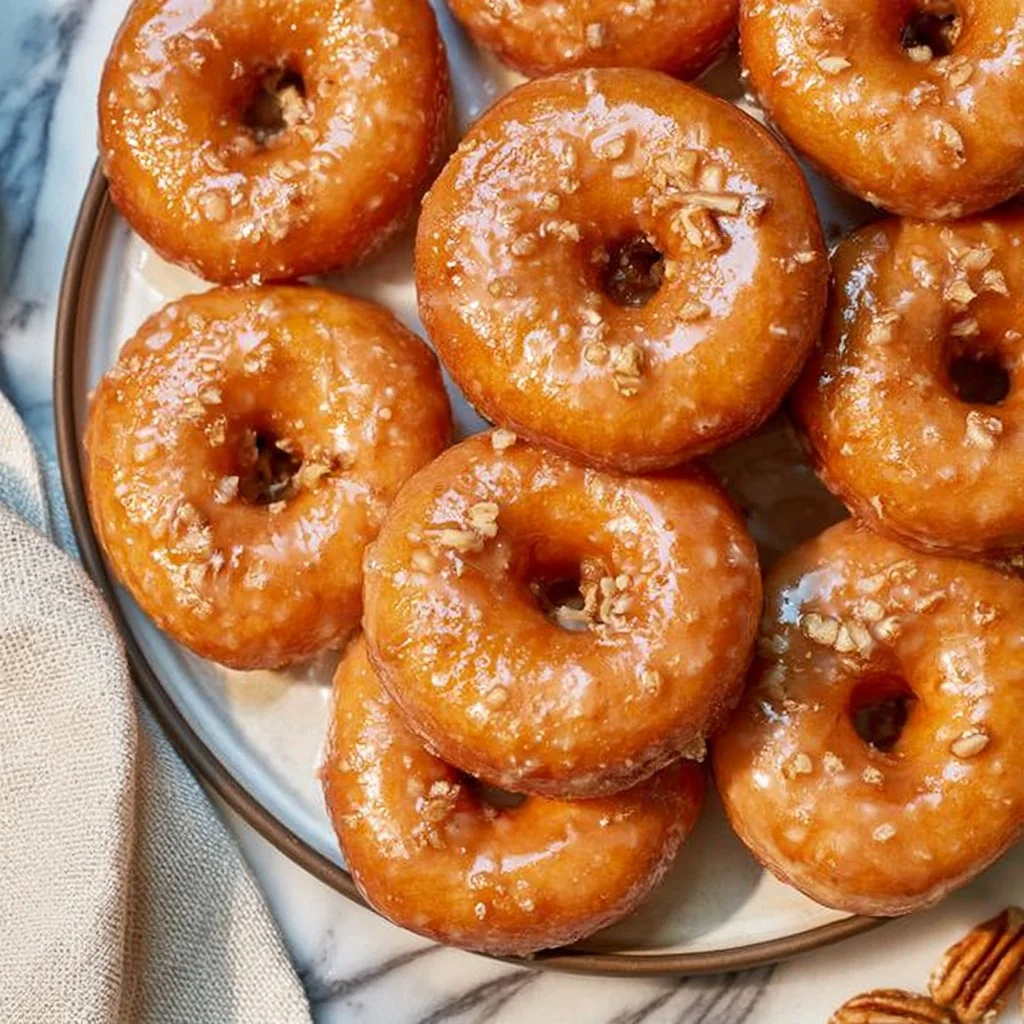 Bakery-style maple glazed yeast donuts with a shiny caramel-colored glaze